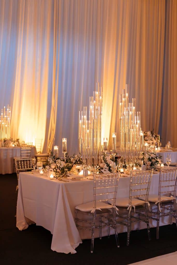 tablescape with lots of different size candles lit, long white curtains, white tablecloth, Naomi Zora Events, Orlando, FL