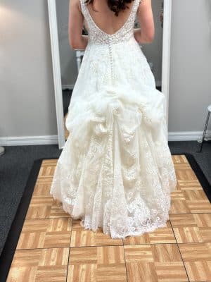 bride standing on a yellow and tan mat wearing her wedding dress, train bustled up, Orlando, FL