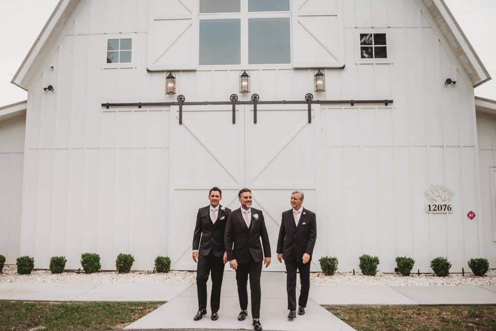 groom and groomsmen standing in front of the horse stables, Orlando, FL
