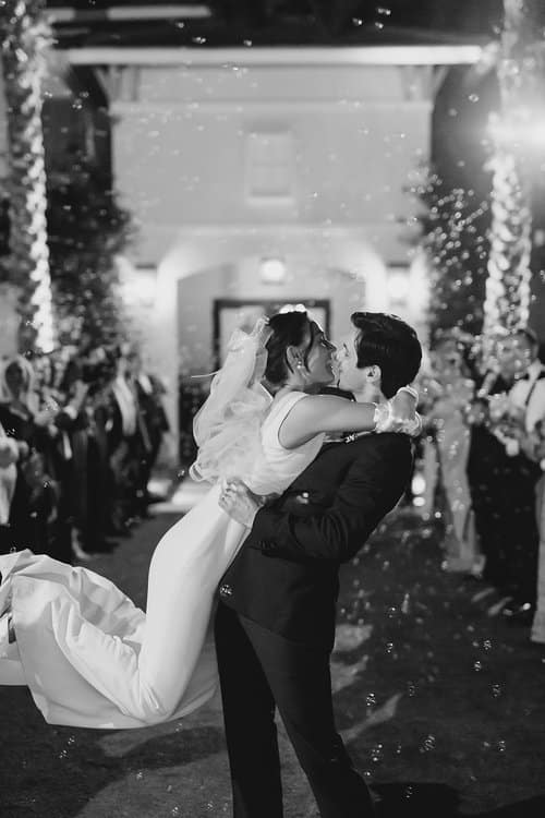 black and white photo, groom and bride kissing while he lifts her off her feet, Orlando, FL