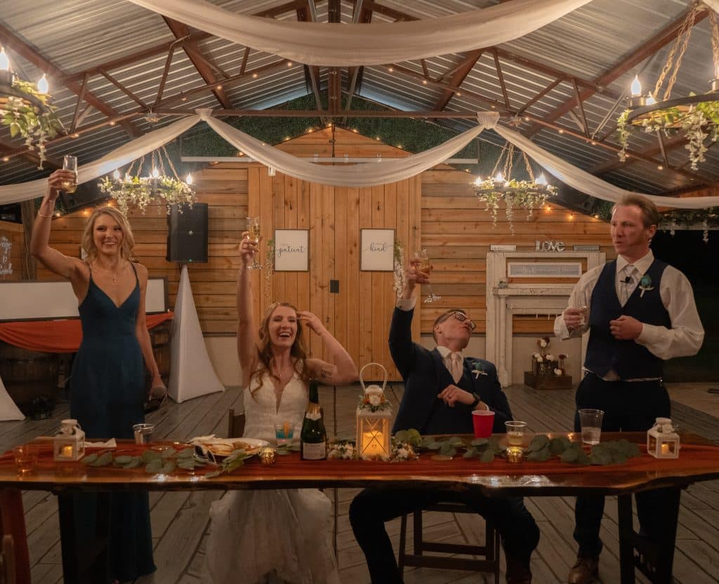 bride and groom at their head table with their maid of honor and best man doing a toast, Orlando, FL