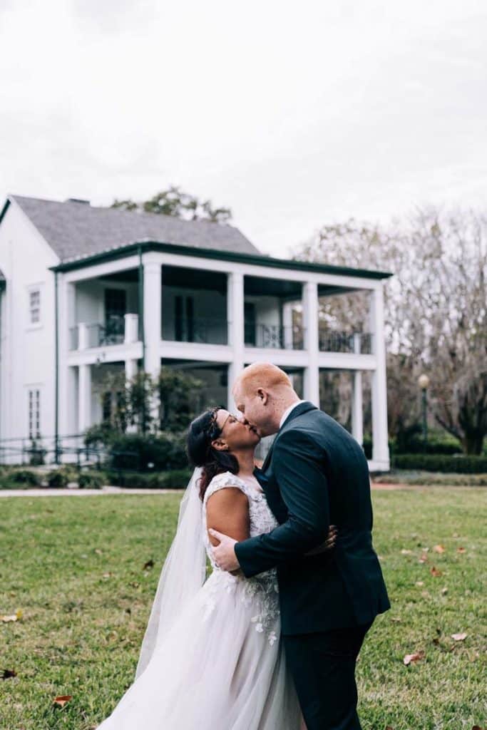 bride and groom kissing on the lawn, venue in the background, Orlando, FL