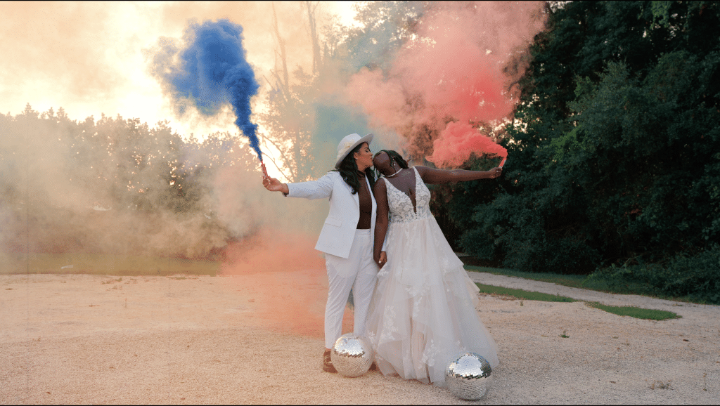 black couple celebrating in their fancy attire with a color bomb of blue and pink, Orlando, FL