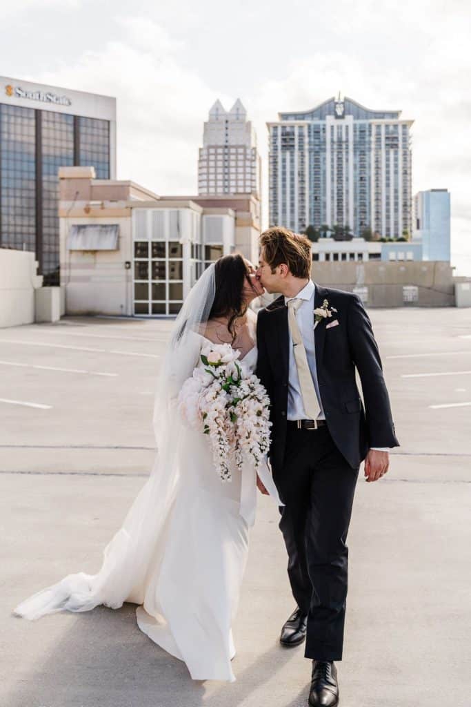 bride and groom kissing on a roof, cityscape in the background, Orlando, FL