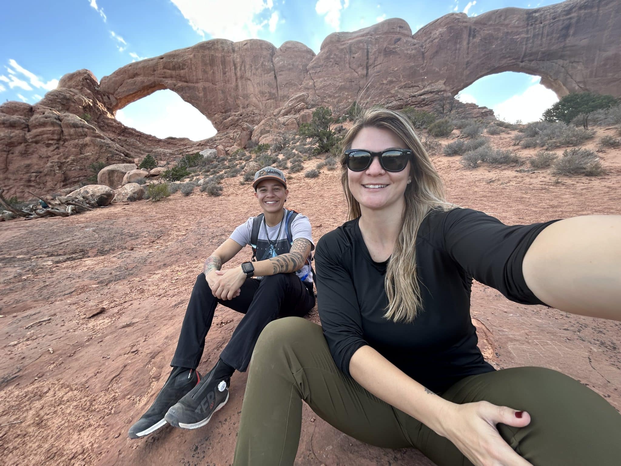 couple sit on rock for picture near rock formation outside