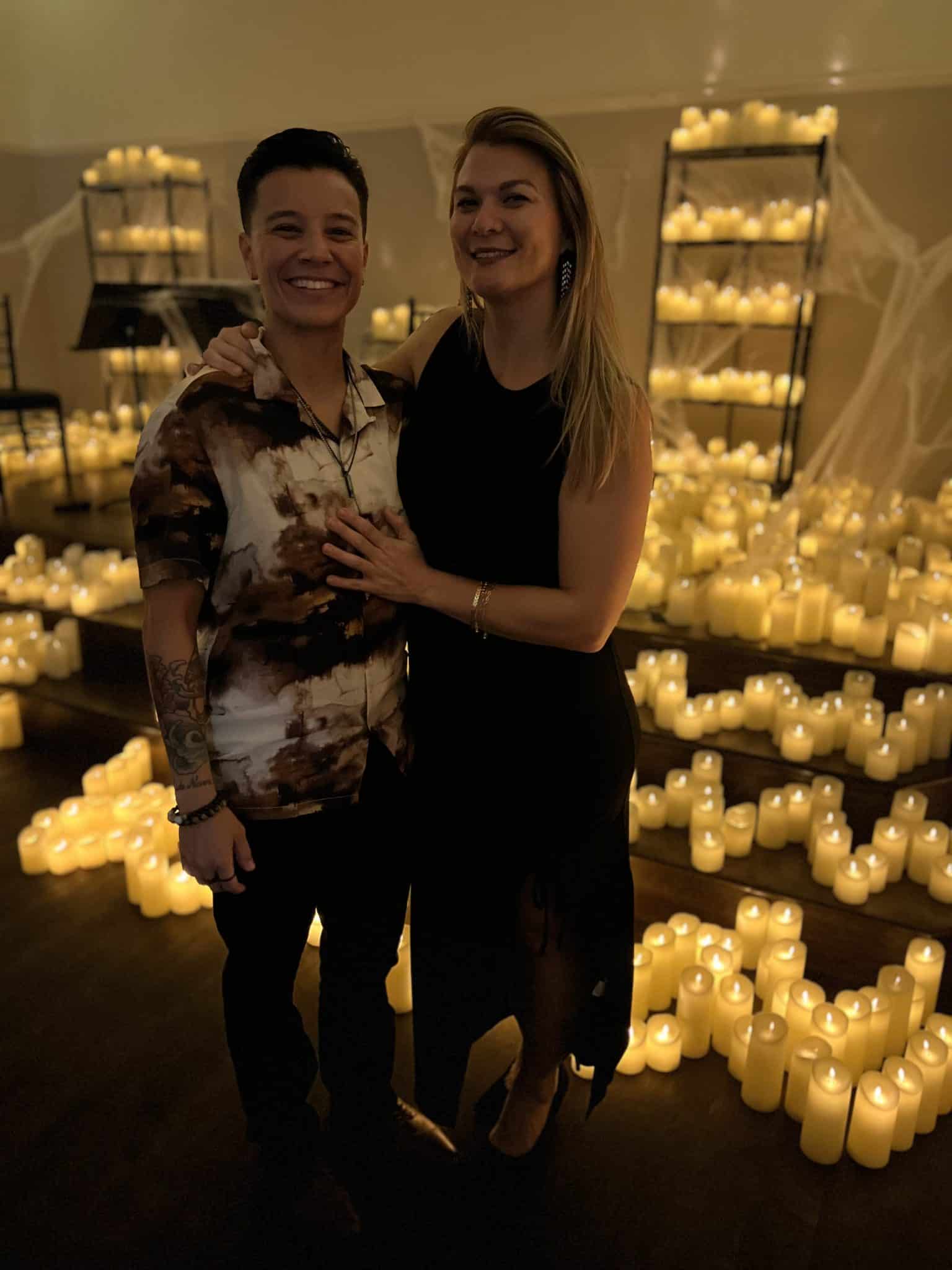 couple stand together for picture in front of candle display