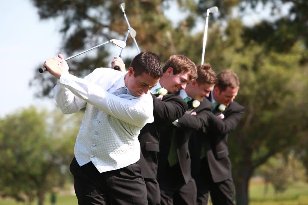 groom and his groomsmen swinging golf clubs in their suits, Falcon's Fire Golf Club, Orlando, FL