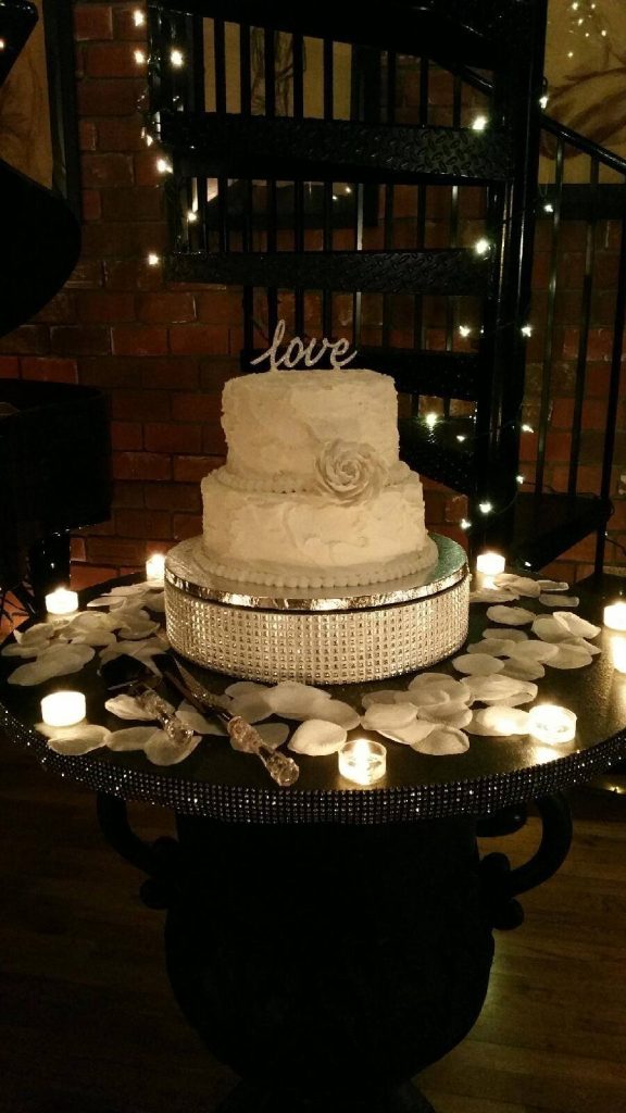 3 tiered wedding cake, white fondant, LOVE atop the cake, black spiral staircase, white petals on the table, Orlando, FL