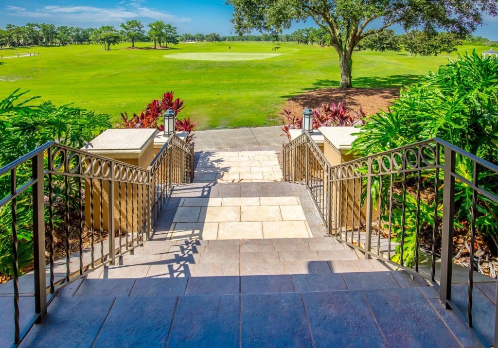 grand staircase leading outside to the golf course, stone steps, beautiful plants alongside, Orlando, FL