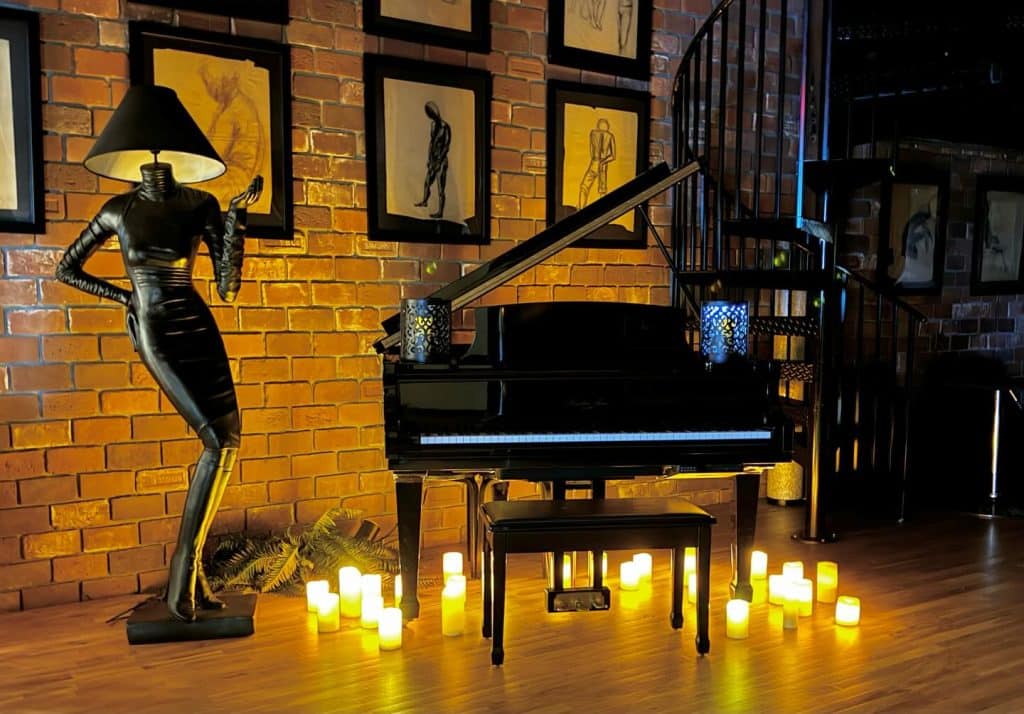 baby grand piano, tea lights, spiral staircase, brick wall with silhouettes in frames, mannequin lamp, Orlando, FL