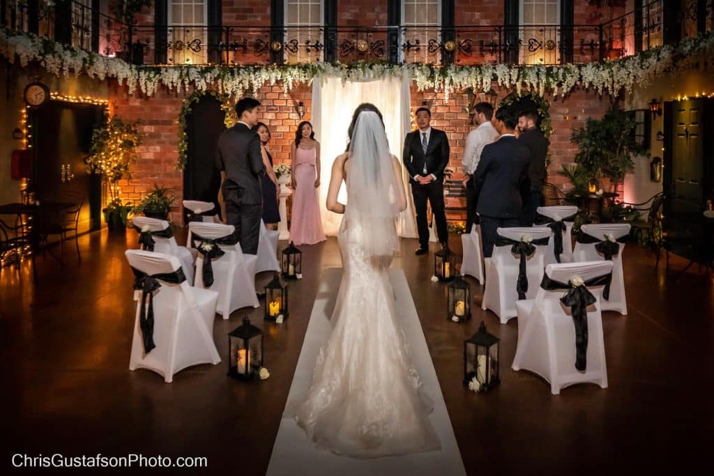 bride walking down the aisle, white chairs adorned with white covers and black bows, evening ceremony, intimate, Orlando, FL