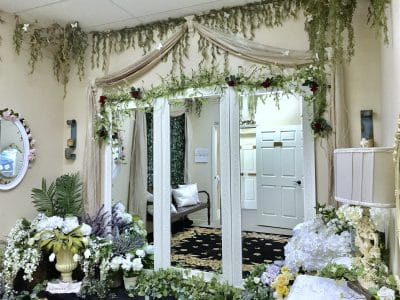 indoor area of Gallery J, moss and greenery hanging from the ceiling, white curtains, white doors, white flowers, Orlando, FL
