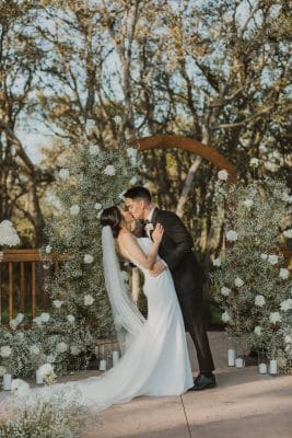 wedding couple kissing, surrounded by flowers and trees, Sterling Event Venue, Orlando, FL