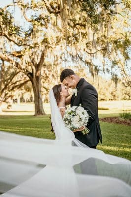 bride and groom kissing with her veil blowing in the breeze, Orlando, FL