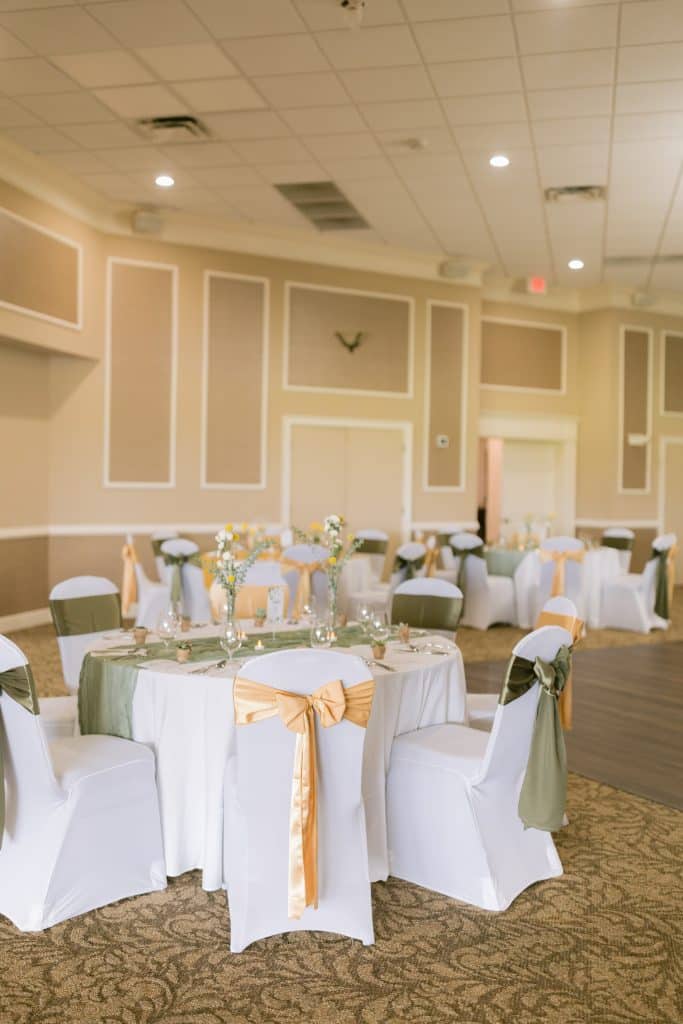 indoors, white tablecloths, olive green runners, yellow bows on chair back covers, Orlando, FL