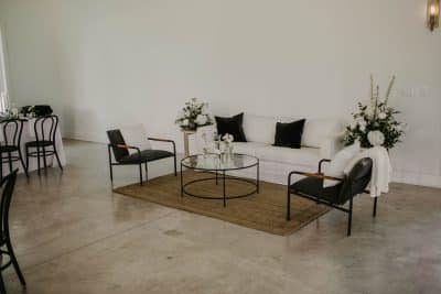 table set up with black chairs and white tablecloth, white floral arrangements on each end of the table, Orlando, FL