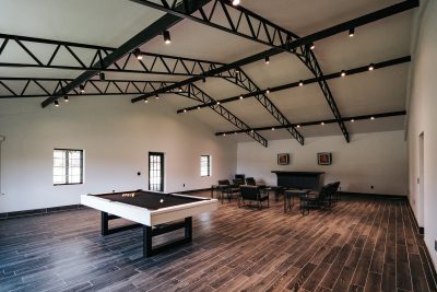 game room area of the wedding venue, pool table, fireplace, chairs arranged in a circle, wood floors, Orlando, FL