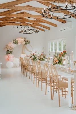 shower set up, wood rafters, white floor balloon arrangement in the background, wooden chairs, floral centerpieces, Orlando, FL