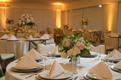 wedding reception, round tables, white napkins, white plates, white tablecloths, yellow uplighting, floral centerpieces, Rio Pinar Golf & Country Club, Orlando, FL