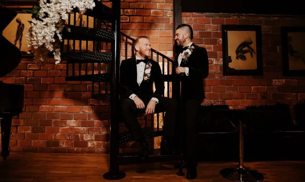 Groom and his best man standing near the black spiral staircase, Gallery J, Orlando, FL