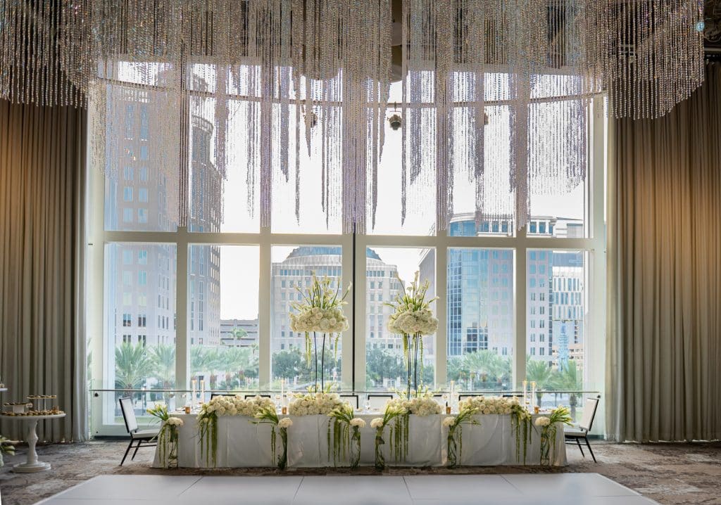 large ballroom with dinner table, tall floral arrangements, large cascading windows, Orlando, FL