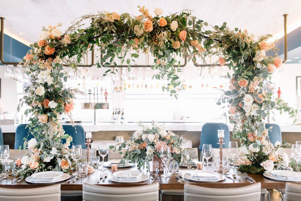 reception set up on deck, floral arrangement arching above, bar behind, Orlando, FL