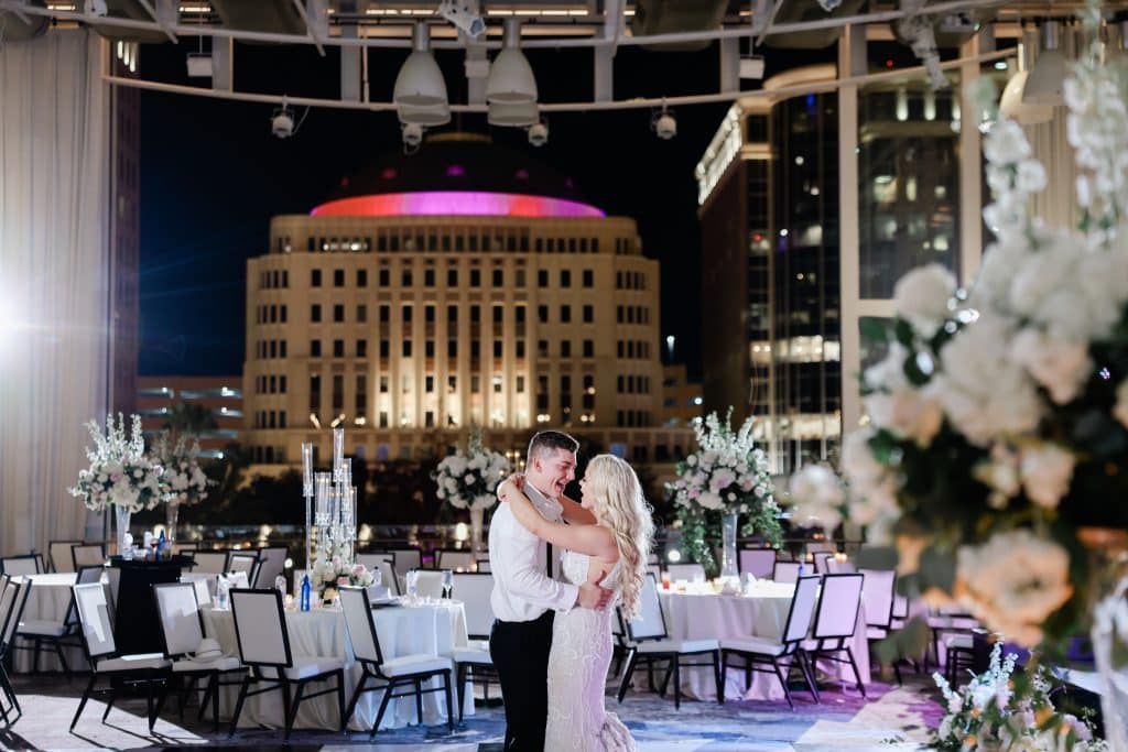 bride and groom embracing and dancing, city scape design in the background, Orlando, FL