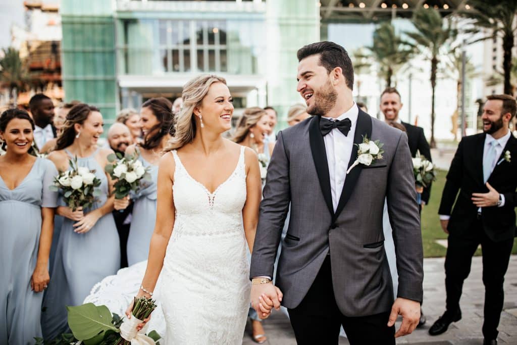 bride and groom walking hand in hand, looking at each other after their wedding ceremony, Orlando, FL