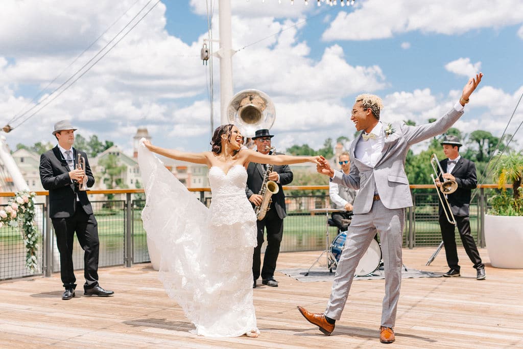 bride and groom dancing at their reception, excited for their special day, musical group behind playing for them, Orlando, FL