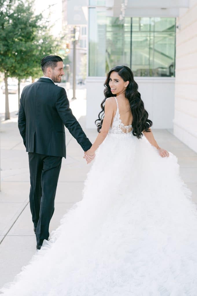 bride and groom walking on the street, looking back at the camera, Dr. Phillips Center for Performing Arts, Orlando, FL