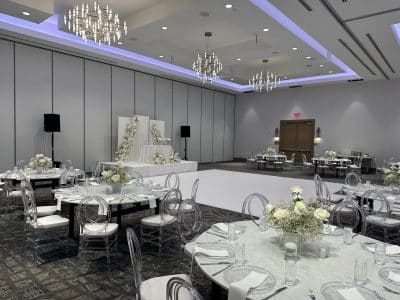 wedding reception, white dance floor, purple lighting, clear chairs with white cushions, clear chargers, white napkins, white floral centerpieces, Orlando, FL