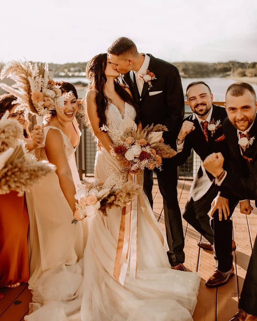 wedding couple kissing at their ceremony as guests watch and cheer them on, Orlando, FL