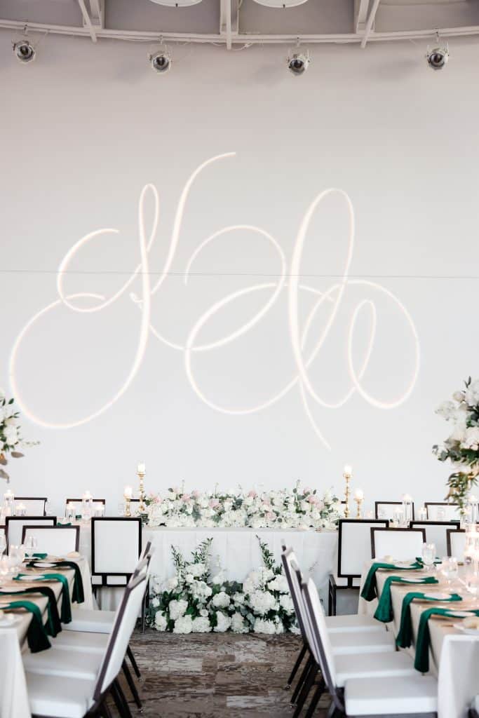 wedding reception set up with long tables, white tablecloths, green napkins, track lighting, Orlando, FL