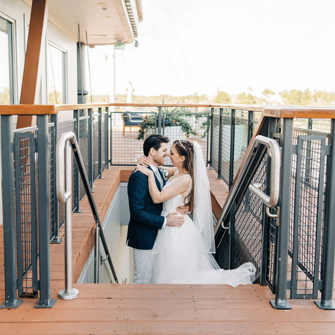 wedding couple looking into each other's eyes, standing on the stairs, heading to the lower deck, Orlando, FL