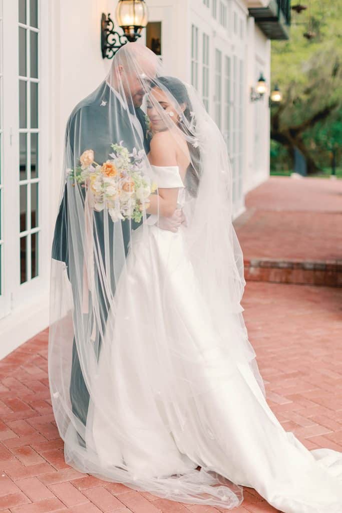 bride and groom embracing, covered by the bride's veil, Orlando, FL