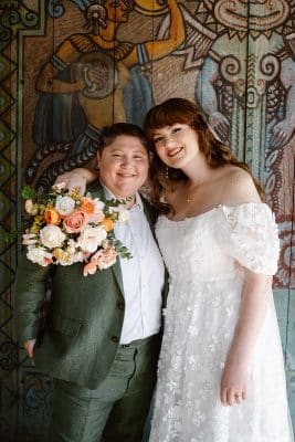 wedding couple posing together, orange and white floral bouquet, same sex couple, Orlando, FL