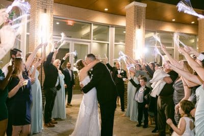 bride and groom kissing as their guests celebrate their wedding, Orlando, FL