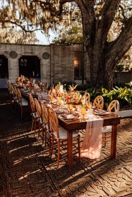 reception table set up, peach runner, eight place settings, wooden chairs, Orlando, FL