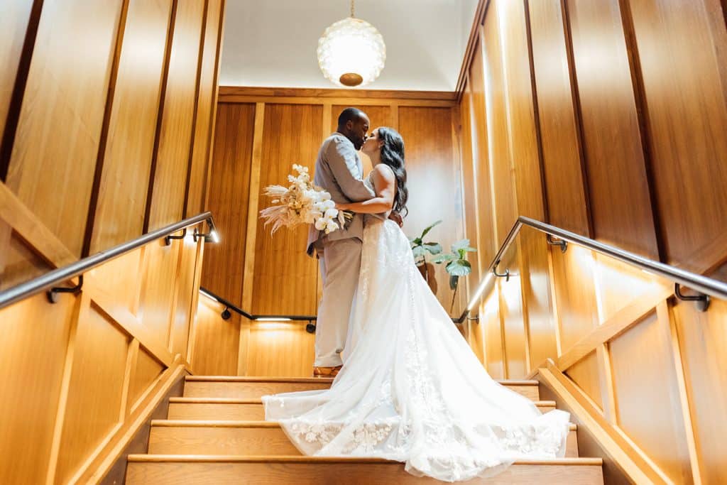 wedding couple on the grand staircase, wood panel walls, Orlando, FL