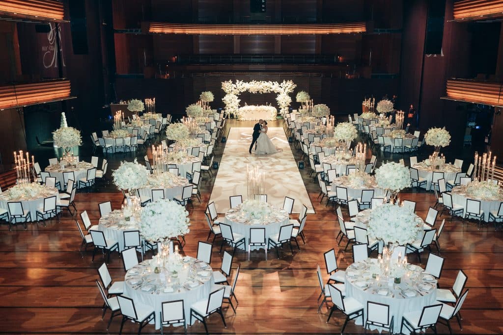 view from above of the reception set up, round tables around the room with a long white dance floor in the middle, bride and groom standing in the center, Dr. Phillips Center for Performing Arts, Orlando, FL