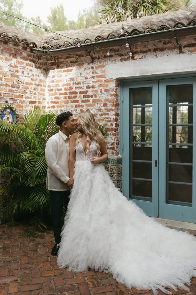 bride and groom kissing in their wedding attire, outside the venue, Orlando, FL