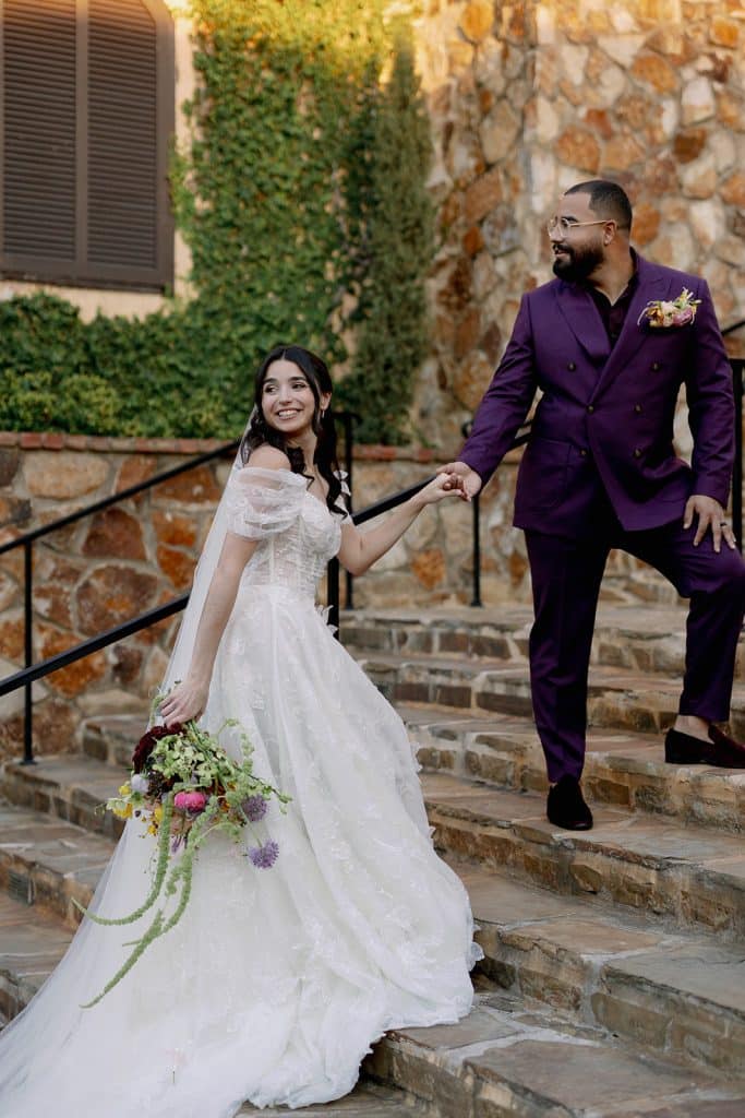 groom leading his bride up the stairs, looking back, Melanie Paige Events + Design, Orlando, FL