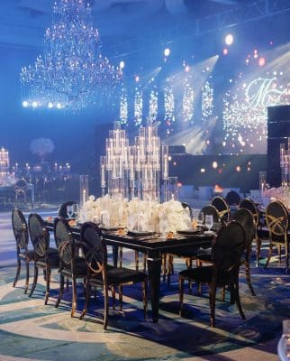 ballroom setting, reception set up, black tables with black chairs, candles, chandelier, lights, screen on stage, the Ritz-Carlon Orlando Grand Lakes, Orlando, FL
