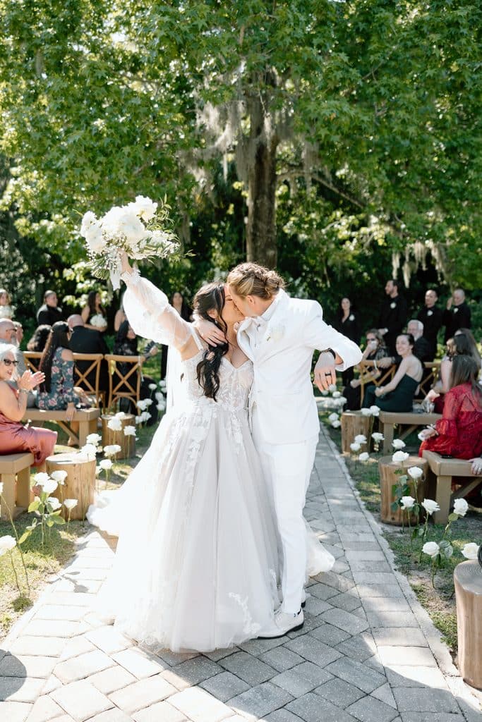 wedding couple in all white, celebrating in the aisle after their ceremony, Melanie Paige Events + Design, Orlando, FL