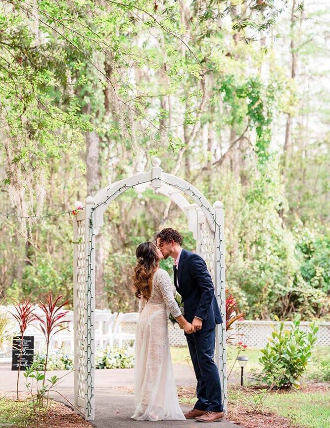 Little Paradise Wedding Venue, bride and groom kissing at the altar, outdoors, trees, Orlando, FL