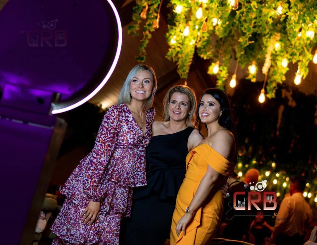 wedding guess posing for the Photo Booth, outdoors, tree lit up behind them, nighttime, CRB Entertainment, Orlando, FL