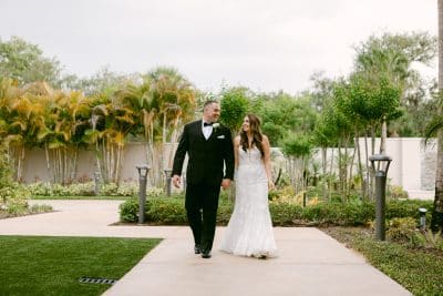 bride and groom walking in the garden of the venue, Orlando, FL