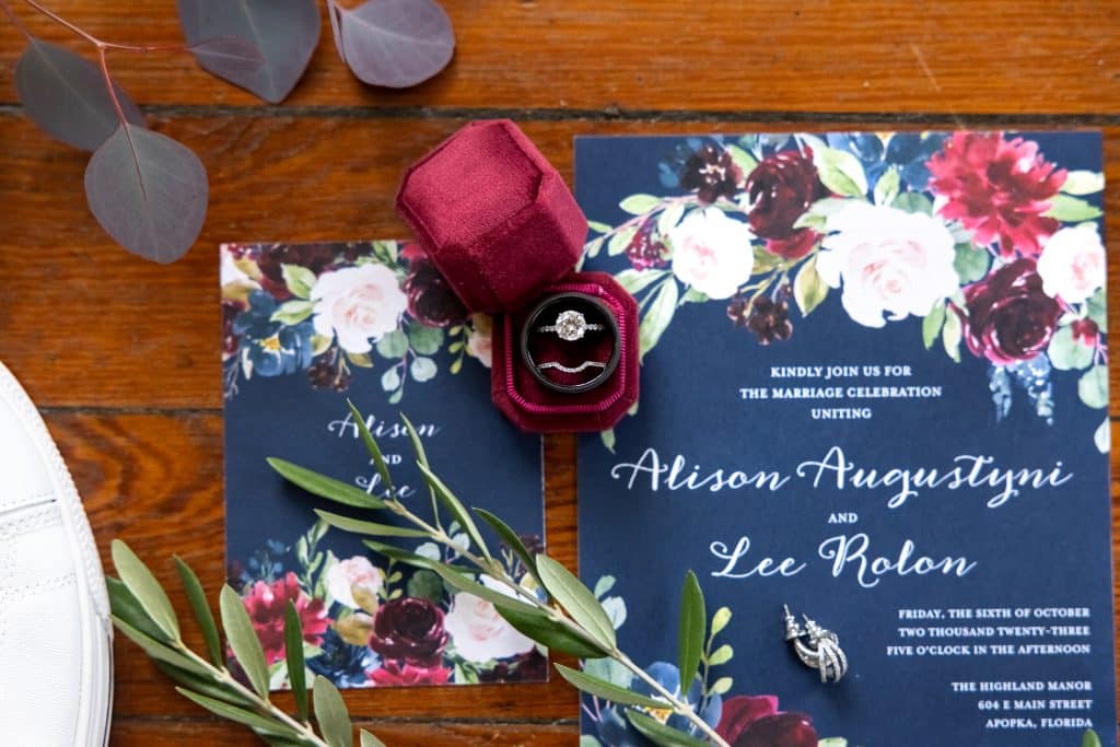 invite card for burgundy and navy wedding with engagement ring in the middle