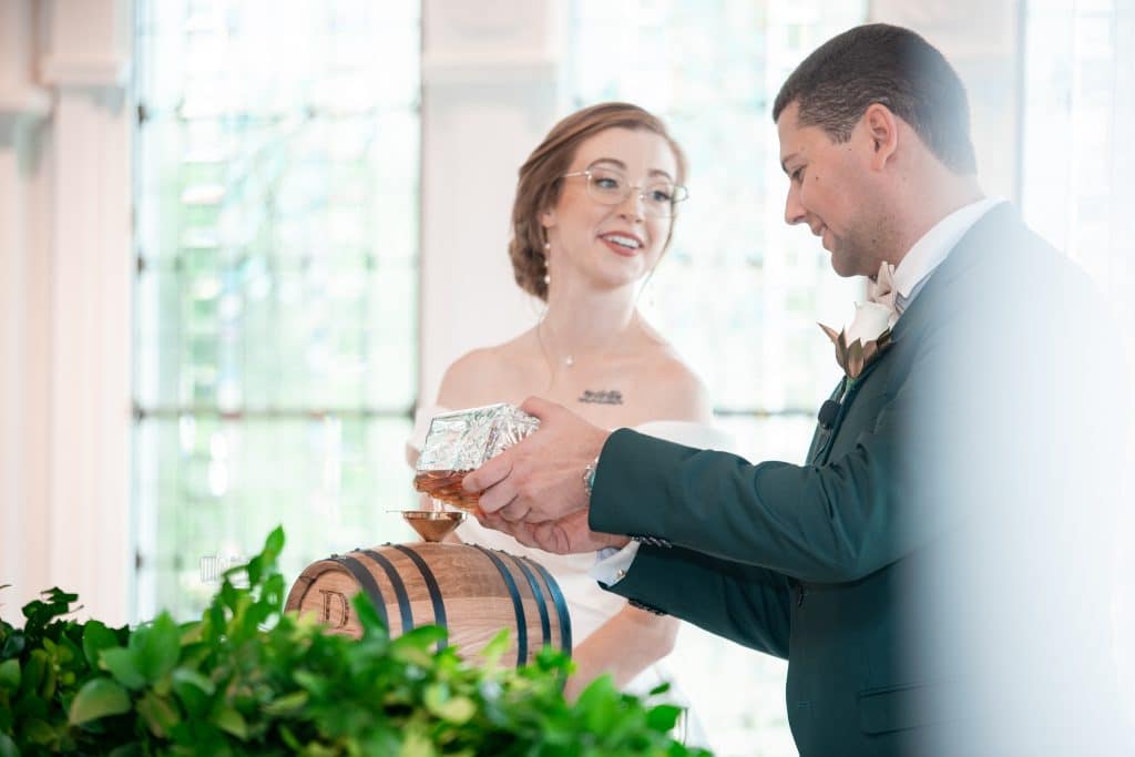 groom and bride image of them pouring bourbon for their unique bourbon-blending ceremony