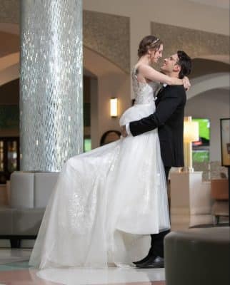 groom lifting his bride up, embracing her before they kiss, Orlando, FL